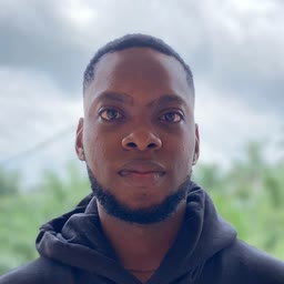 Chuks Ben Okafor, outdoors against trees and an overcast sky
